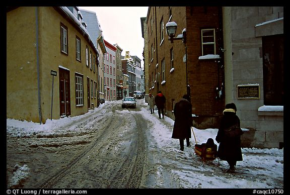 Residents pulling a sled with a child in a street, Quebec City. Quebec, Canada (color)