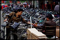 Woman checking out her bicycle at a bicycle lot. Kunming, Yunnan, China ( color)