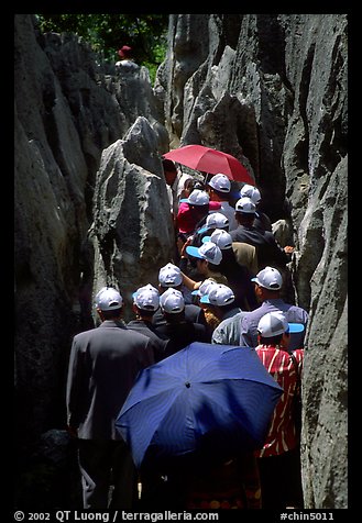 Crowds of Chinese tourists in a walkway among the limestone pillars. Shilin, Yunnan, China (color)