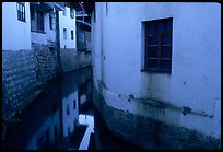 White walled houses surrounding a canal. Lijiang, Yunnan, China (color)