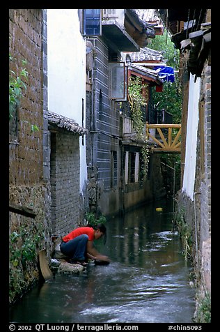 Woman washes clothes in the canal. Lijiang, Yunnan, China (color)