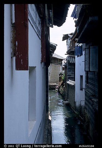 Canal sneaking narrowly between walls. Lijiang, Yunnan, China