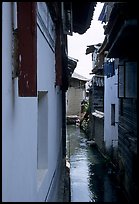 Canal sneaking narrowly between walls. Lijiang, Yunnan, China