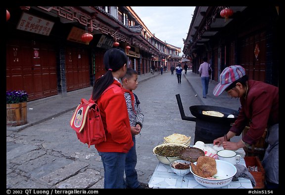 Schoolchildren get Naxi flatbread for breakfast. Lijiang, Yunnan, China