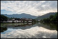 Village and clouds reflected in South Lake. Hongcun Village, Anhui, China
