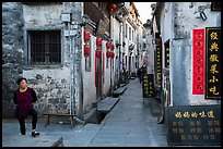 Woman standing next to main street. Xidi Village, Anhui, China