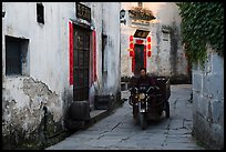 Man driving motobike carriage in narrow street. Xidi Village, Anhui, China