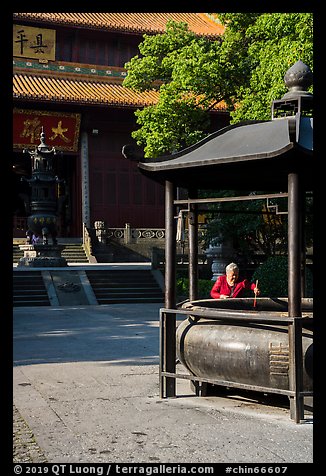 Woman at incense urn, Jingci Temple. Hangzhou, China (color)