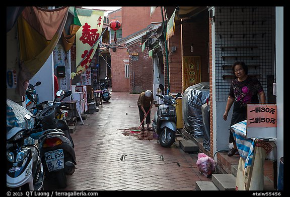 Woman cleaning in alley. Lukang, Taiwan