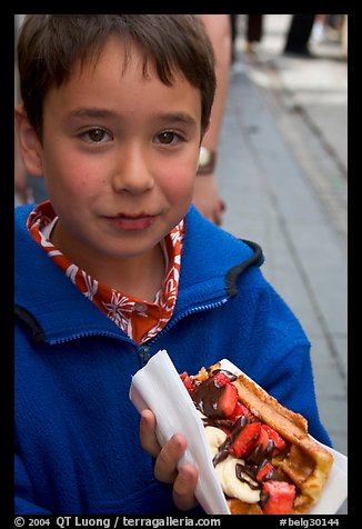 Boy eating a Belgian waffle. Brussels, Belgium