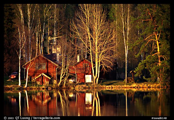 Wooden house reflected in a lake at sunset. Central Sweden