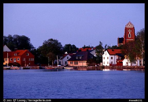 Houses, church, across the lake at dusk, Vadstena. Gotaland, Sweden