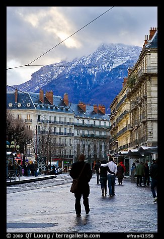 Downtown street and snowy mountains of the Belledone Range. Grenoble, France