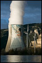 Cooling tower of nuclear power plant with ecology-themed art by Jean-Marie Pierret, and windmill. Provence, France