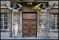 Wooden door framed by sculptures. Aix-en-Provence, France (color)