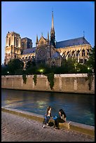Two women having picnic across Notre Dame cathedral. Paris, France (color)