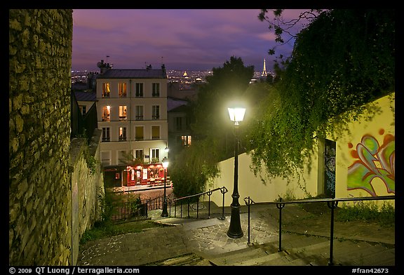 Hillside stairs of butte Montmartre and street lights at sunset. Paris, France