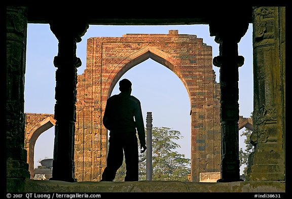 Man at entrance of ruined Quwwat-ul-Islam mosque. New Delhi, India