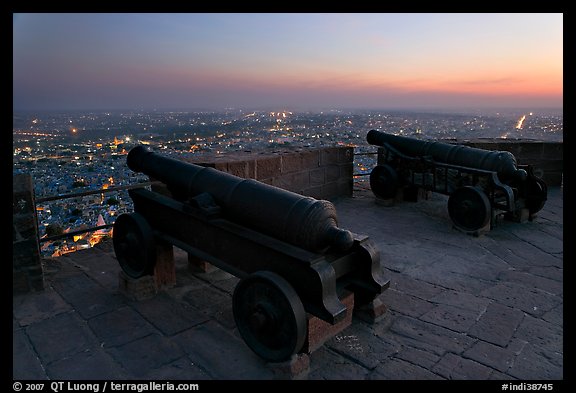 Cannons on top of Mehrangarh Fort, and city lights and dusk. Jodhpur, Rajasthan, India (color)