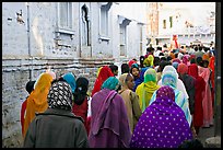 Women in colorful sari walking a  narrow street during wedding. Jodhpur, Rajasthan, India