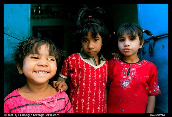 Girls in red dress and blue doors. Jodhpur, Rajasthan, India (color)