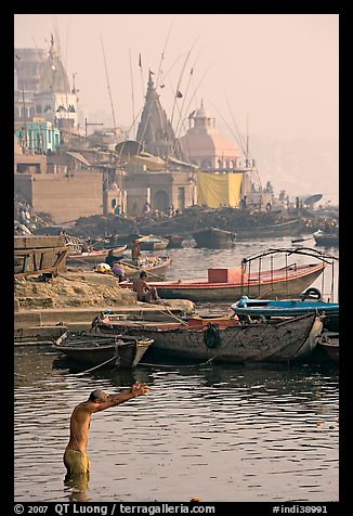 Man with arms stretched standing in Ganga River. Varanasi, Uttar Pradesh, India (color)