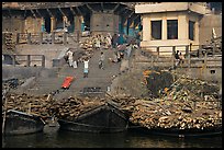 Steps of Manikarnika Ghat with body swathed in cloth and firewood piles. Varanasi, Uttar Pradesh, India (color)