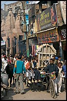 Man moving devotional image and children on rickshaw. Varanasi, Uttar Pradesh, India