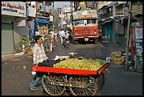 Vegetable vendor pushing cart with truck in background, Colaba Market. Mumbai, Maharashtra, India (color)