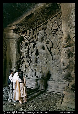 Family looking at Ardhanarishwar Siva sculpture, main Elephanta cave. Mumbai, Maharashtra, India (color)