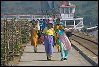 Women walking on  jetty, Elephanta Island. Mumbai, Maharashtra, India ( color)