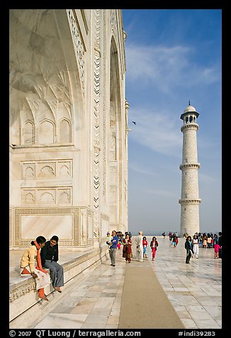 Couple sitting on side pishtaq and tourists strolling on platform, Taj Mahal. Agra, Uttar Pradesh, India