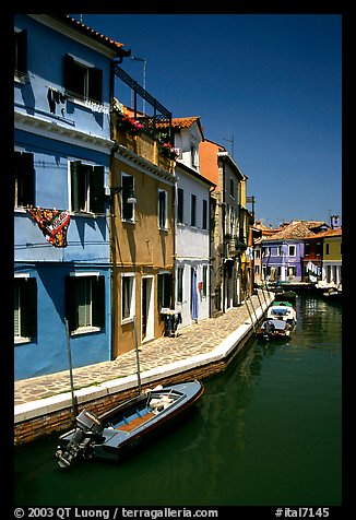 Canal surrounded by houses painted  a multitude of bright colors, Burano. Venice, Veneto, Italy