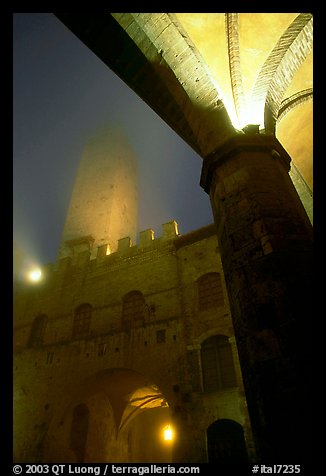 Medieval towers above Piazza del Duomo, foggy night. San Gimignano, Tuscany, Italy