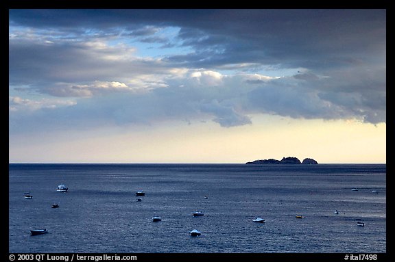 Small boats and Capri Island at sunset, Positano. Amalfi Coast, Campania, Italy