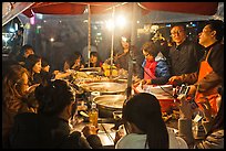 People eating noodles in a tent at night. Seoul, South Korea ( color)