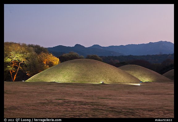 Illuminated tumuli at dusk and hills. Gyeongju, South Korea (color)