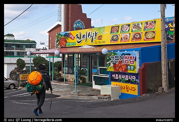 Haeneyo woman walking towards seafood restaurant. Jeju Island, South Korea
