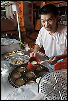 Man preparing mini-pancakes. George Town, Penang, Malaysia