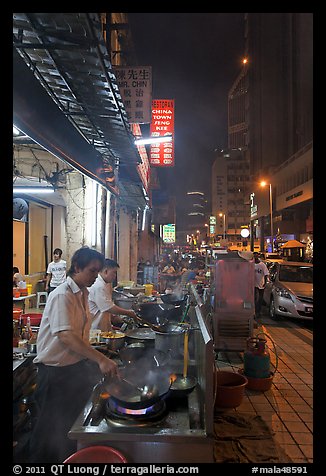 Cooks preparing food on Chinatown street at night. Kuala Lumpur, Malaysia