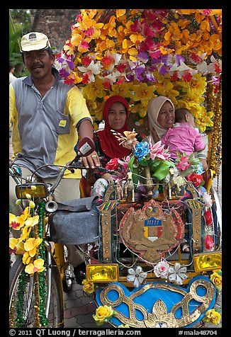 Decorated trishaw driver and passengers. Malacca City, Malaysia (color)