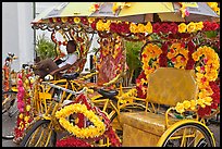 Trishaws decorated with plastic flowers. Malacca City, Malaysia ( color)