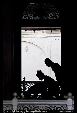 Silhouettes of men bowing in worship, Masjid Kampung Hulu. Malacca City, Malaysia (color)
