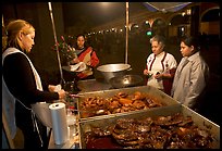 Women buying food at a food stand by night, Tlaquepaque. Jalisco, Mexico (color)