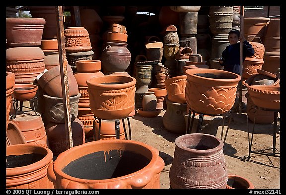 Boy standing next to clay pots, Tonala. Jalisco, Mexico