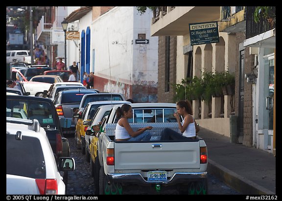 Young women riding in the back of a pick-up truck in a busy street, Puerto Vallarta, Jalisco. Jalisco, Mexico