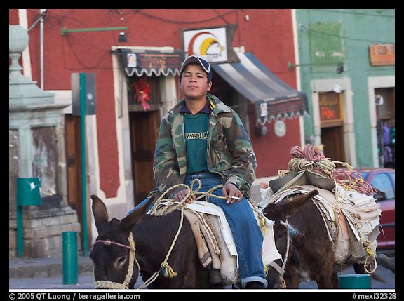 Young man riding a donkey in the streets. Guanajuato, Mexico