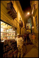 Man at a Newstand booth in a narrow callejone at night. Guanajuato, Mexico
