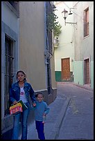 Woman and child walking in a narrow street. Guanajuato, Mexico
