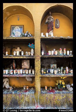 Candles, flowers, and religious offerings in a roadside chapel. Mexico